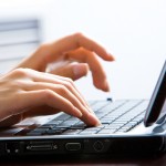 Image of female hands on the keys typing documents